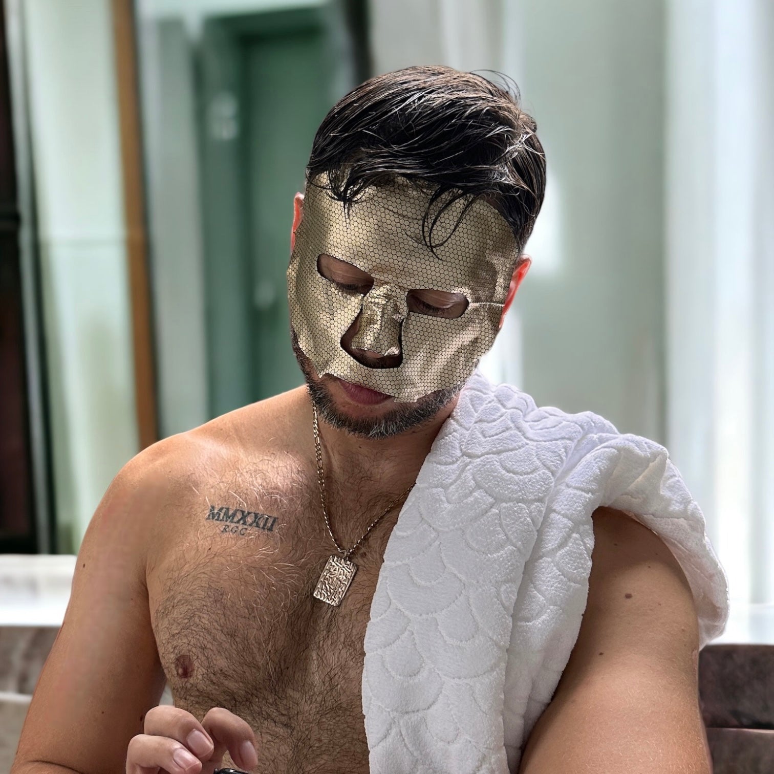 Man wearing a gold foil hydration sheet mask by MDRN.